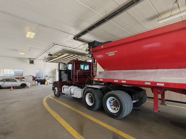 Red semi truck inside the inspection bay at James Drive Safety Lane.