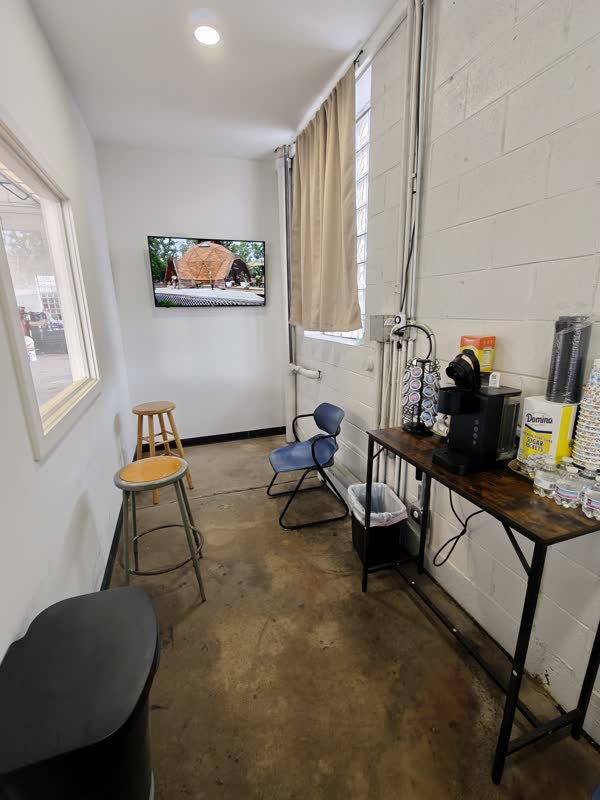 Customer waiting room with TV, seating, and coffee station.